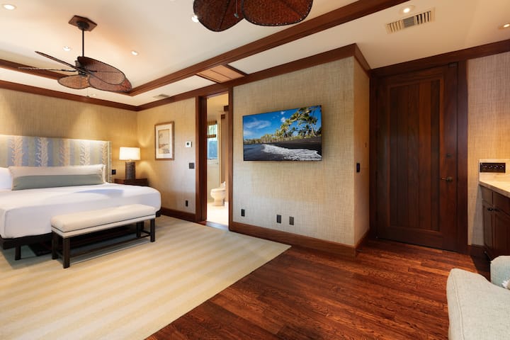 Cómodo dormitorio con TV inteligente, cocina pequeña y cálidos acabados en madera.