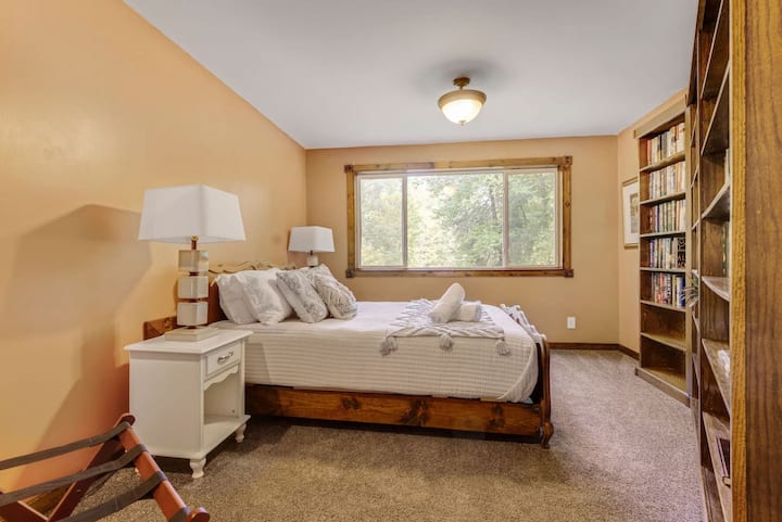 Bedroom 2 – Loft Bedroom
Open loft sleeping space with a queen bed overlooking the dome living area below. This space does not have a door. It offers incredible views of the woods and stream as well as a cozy library.