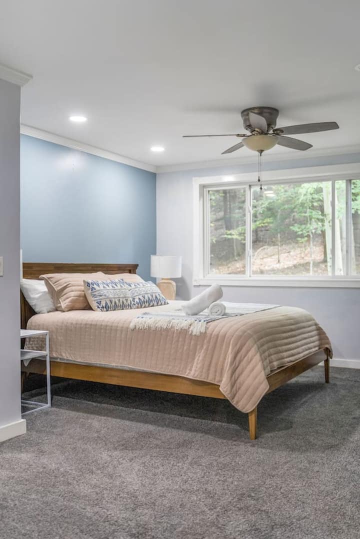 Bedroom 1 – Primary Suite
King bed with incredible views of the surrounding woods. This relaxing retreat features an electric fireplace, streaming TV and a beautifully updated private ensuite bathroom with modern finishes.