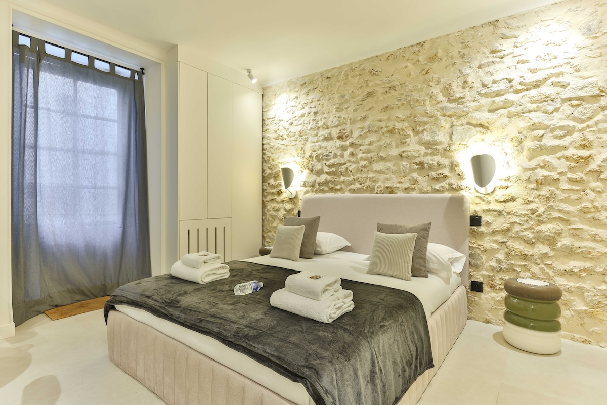 Een woonruimte met een tweepersoonsbed, ideaal om te ontspannen na een dag wandelen door Parijs.