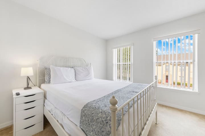 Просторна стая за гости с удобно двойно легло и два големи прозореца, които изпълват помещението с естествена светлина, създавайки светла и приветлива атмосфера.