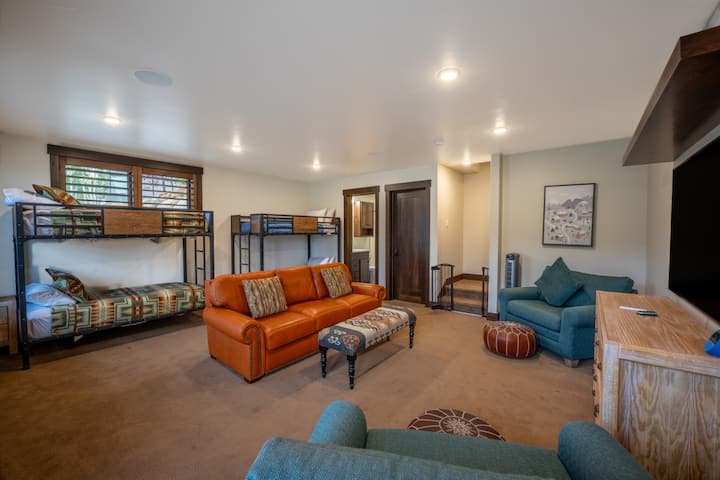 מפלס תחתון - חדר משחקים וחדר שינה לאורח רביעי עם שתי מיטות קומותיים, ספה נפתחת ושתי מיטות נפתחות