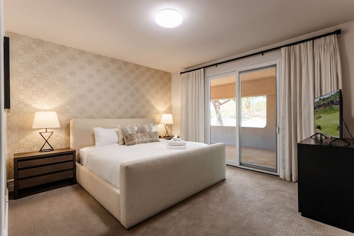 غرفة نوم رابعة تضم سرير كينج وتلفزيون ذكي وخزانة ملابس كبيرة وحمام داخلي وإمكانية الوصول إلى الفناء الأمامي.