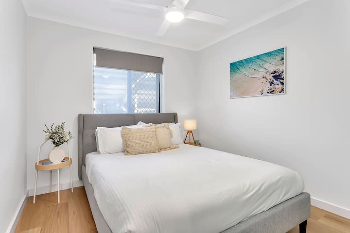 Oddýchnite si v druhej izbe s manželskou posteľou, ktorá je vybavená pohodlnou posteľnou bielizňou a teplým osvetlením a vyznačuje sa pokojnou pobrežnou paletou.