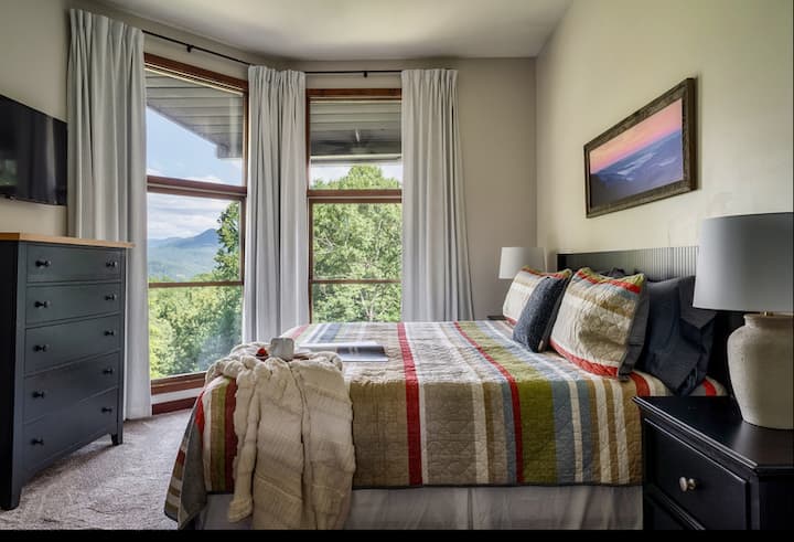 舒适的加大双人床，背景是壮丽的大烟山。