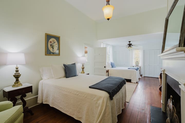 חדר שינה מרווח 2 | מיטות כפולות עם מצעים אלגנטיים | אח חמה ואור טבעי שלו