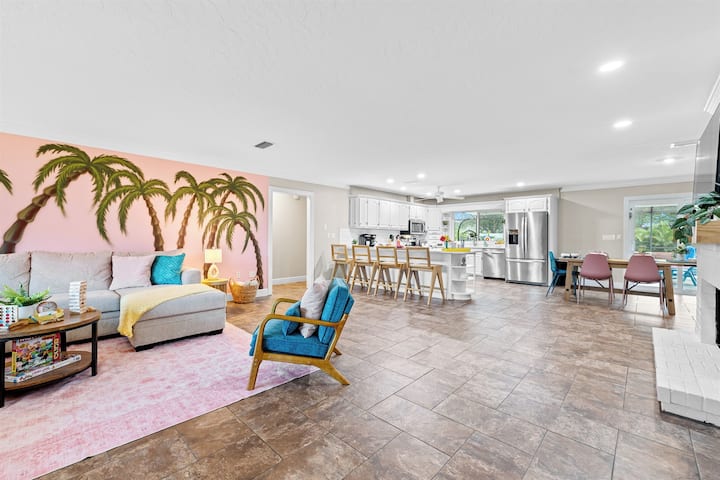 明亮、开放的起居空间，配有有趣的棕榈树墙艺术品、舒适的座位和宽敞的厨房，配有酒吧座位。 现代化的电器、用餐区和温馨的装饰，使这里成为放松身心和聚会的完美场所。