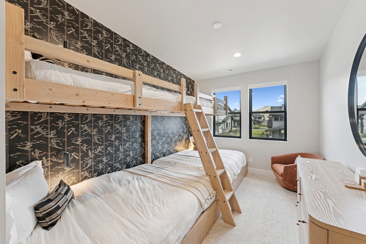 Bunk suite II with wood bunk beds, accent wall, and window views.