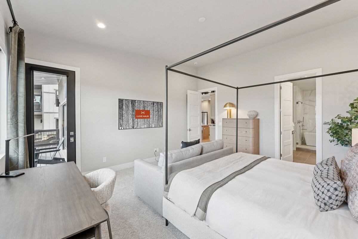 Primary suite with canopy bed, nightstands, and modern décor.