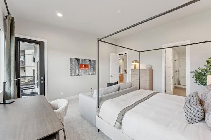 Ensisijainen sviitti, jossa on katosvuode, yöpöydät ja moderni sisustus.