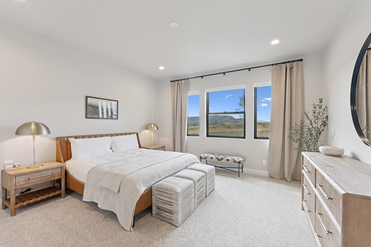 Guest suite bedroom with bed, dresser, and glass doors leading to balcony.
