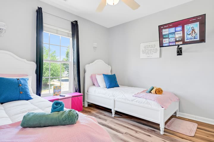 Dormitorio con dos camas individuales y una hermosa vista al patio trasero, perfecto para una estancia relajante.