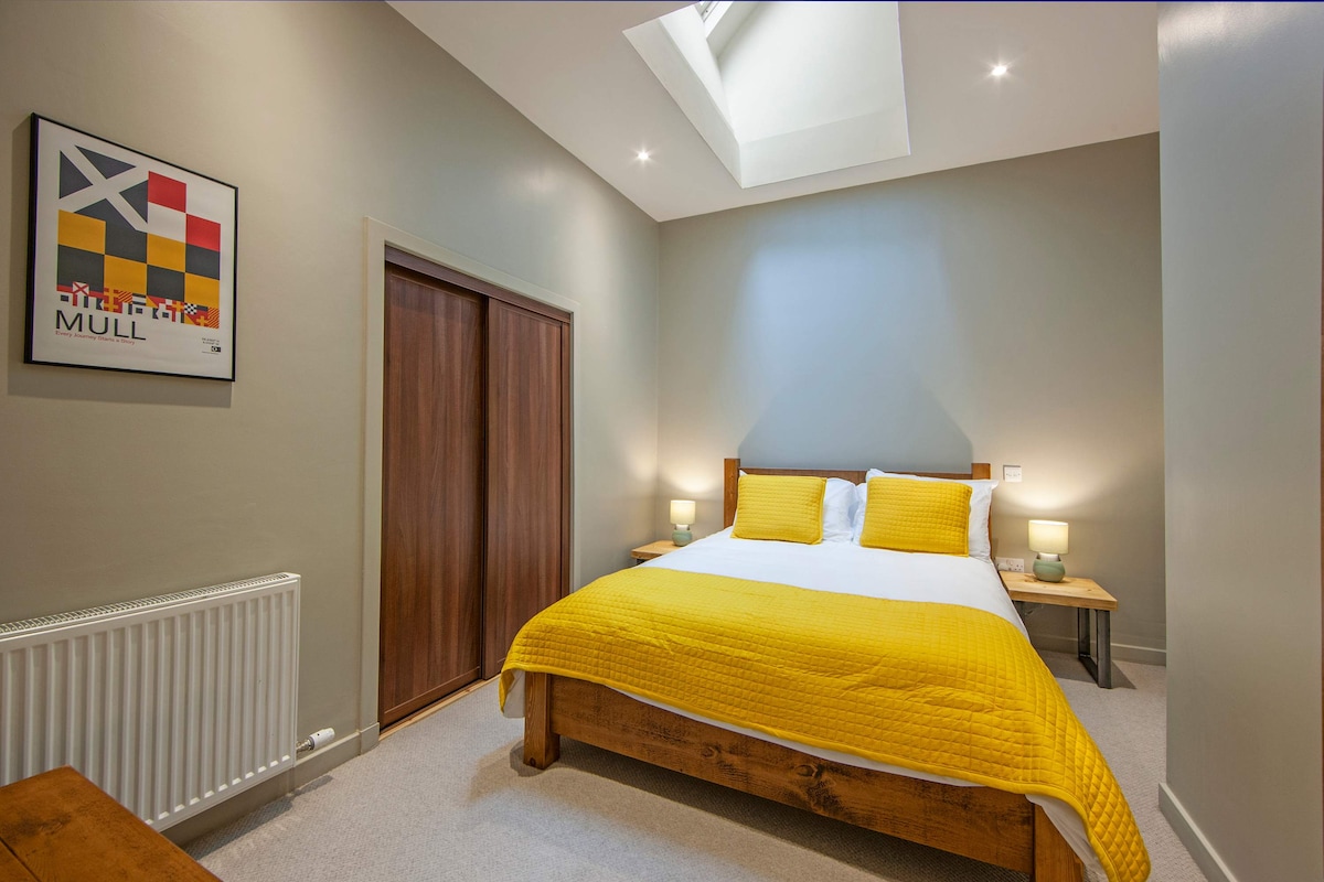 Главна спална соба со поглед кон таванот и топли дрвени тонови