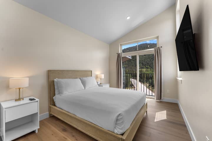 El dormitorio de arriba cuenta con una cama tamaño queen, TV inteligente montada, vistas a la montaña y baño privado. 