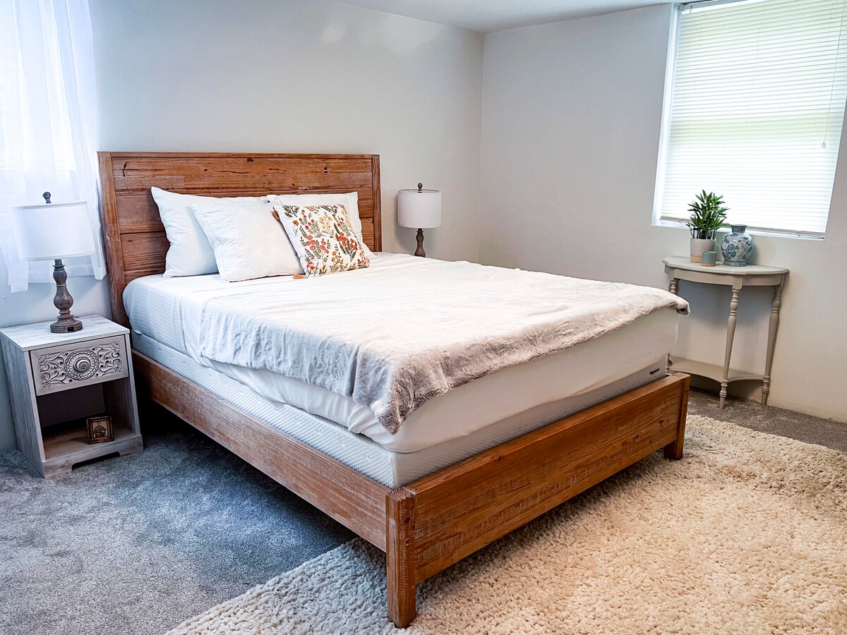 חדר שינה כפרי עם שולחן צד מעץ