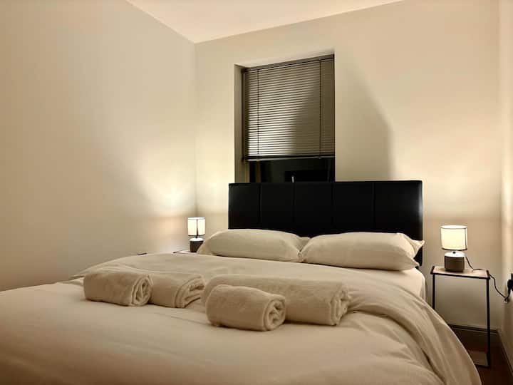 Ambiente relajante en el dormitorio con iluminación suave y decoración moderna. Diseñado para ofrecer comodidad y tranquilidad en el corazón de la ciudad de York.