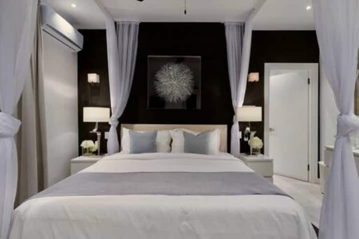 El dormitorio 4 cuenta con una cama tamaño queen del Reino Unido, aire acondicionado, ventilador de techo, televisor inteligente, vestidor, sistema de sonido y un baño privado de lujo.