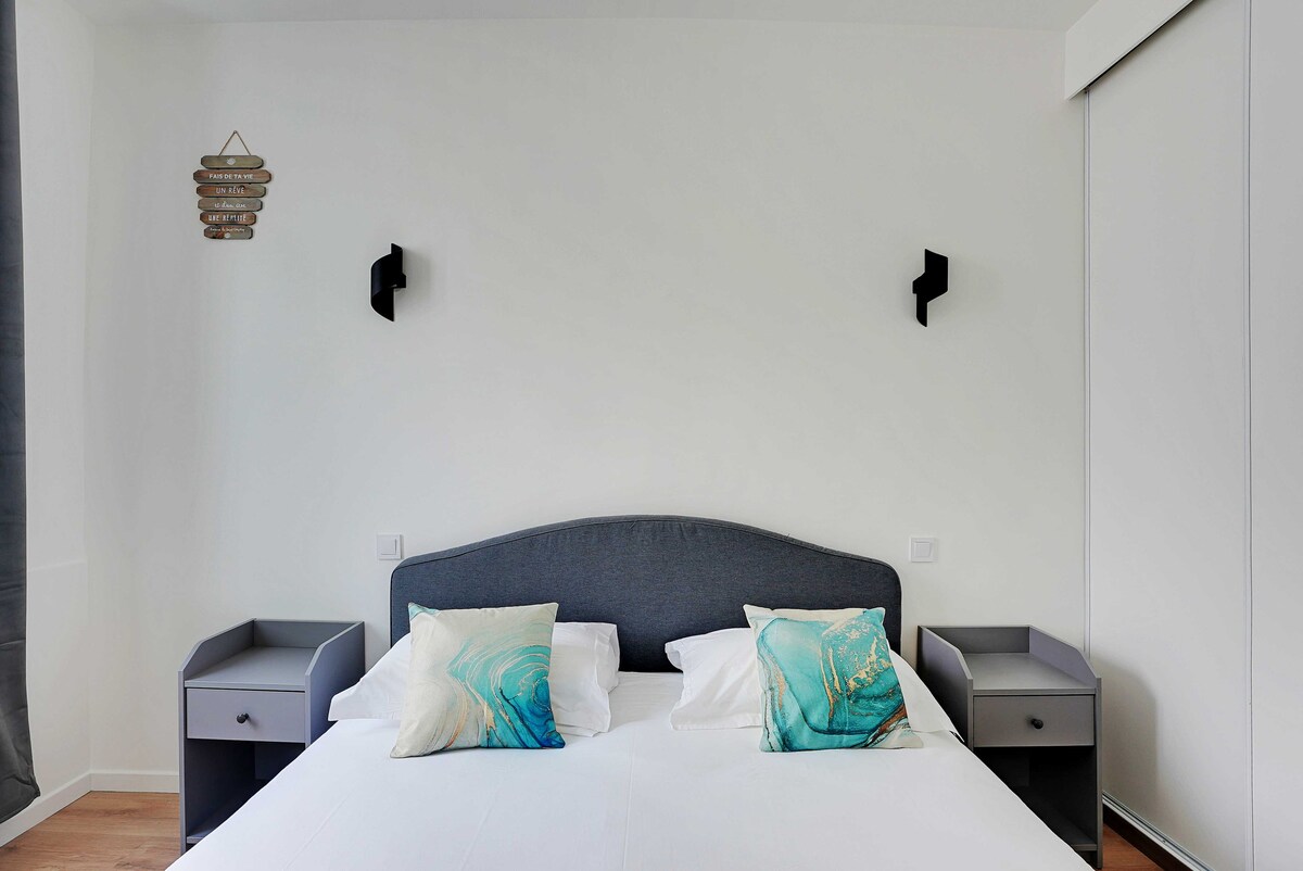 غرفة نوم مع سرير بحجم كوين وتلفزيون وخزانة ملابس