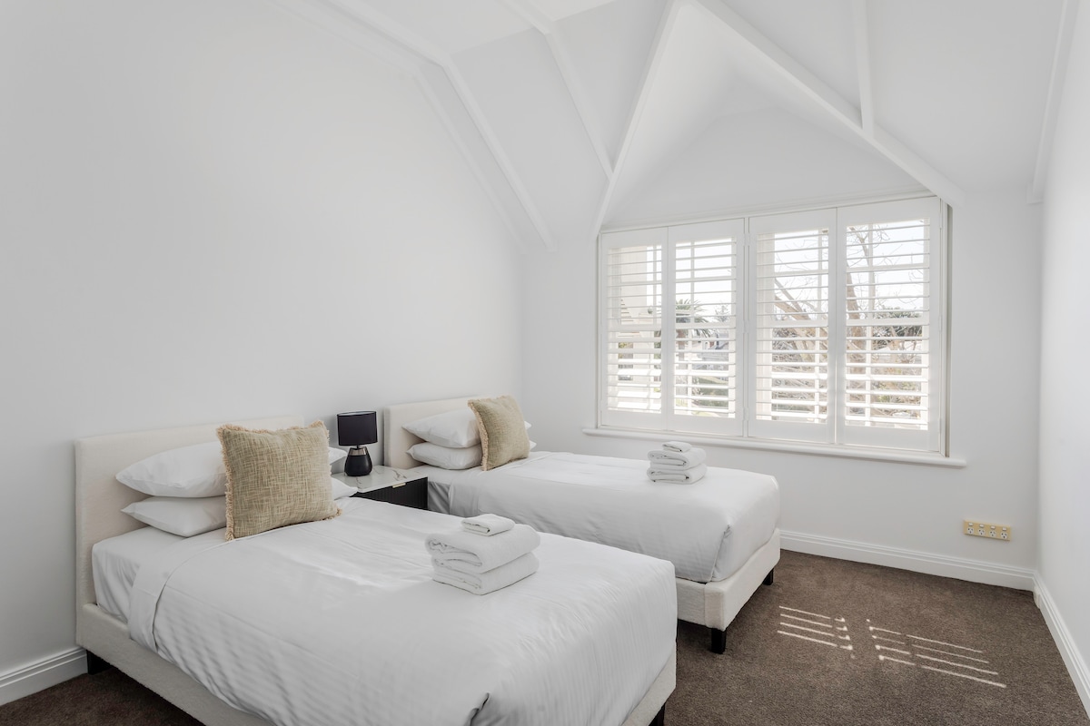 חדר שינה 5 - שתי מיטות יחיד ושפע של מקום לחלוקת בגדים. ליהנות ממרחב מואר שמש עם נוף לגינה