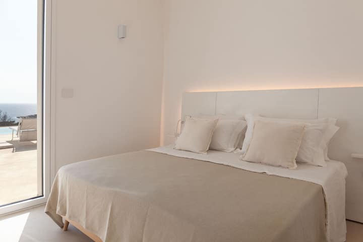 El segundo dormitorio con vistas al mar y acceso a la terraza.