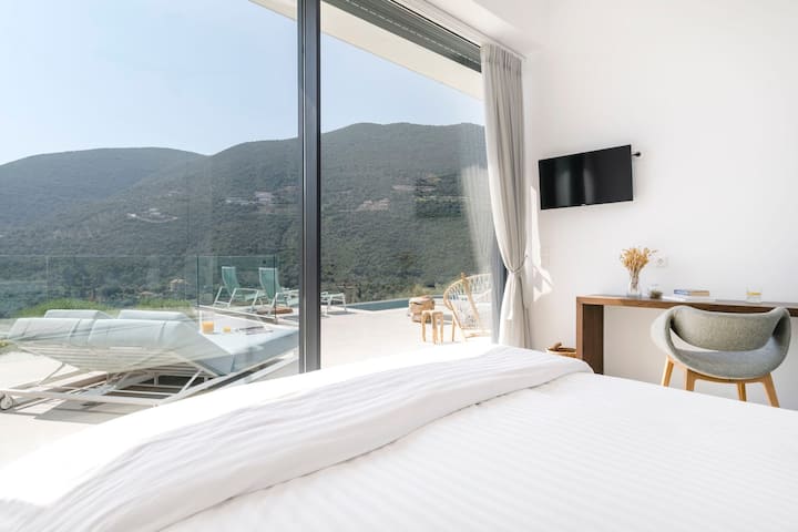 El dormitorio principal con sus gloriosas vistas y una pared de puertas correderas de cristal.