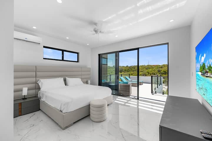 Spavaća soba s mirnim ambijentom i pogledom na vanjski prostor.