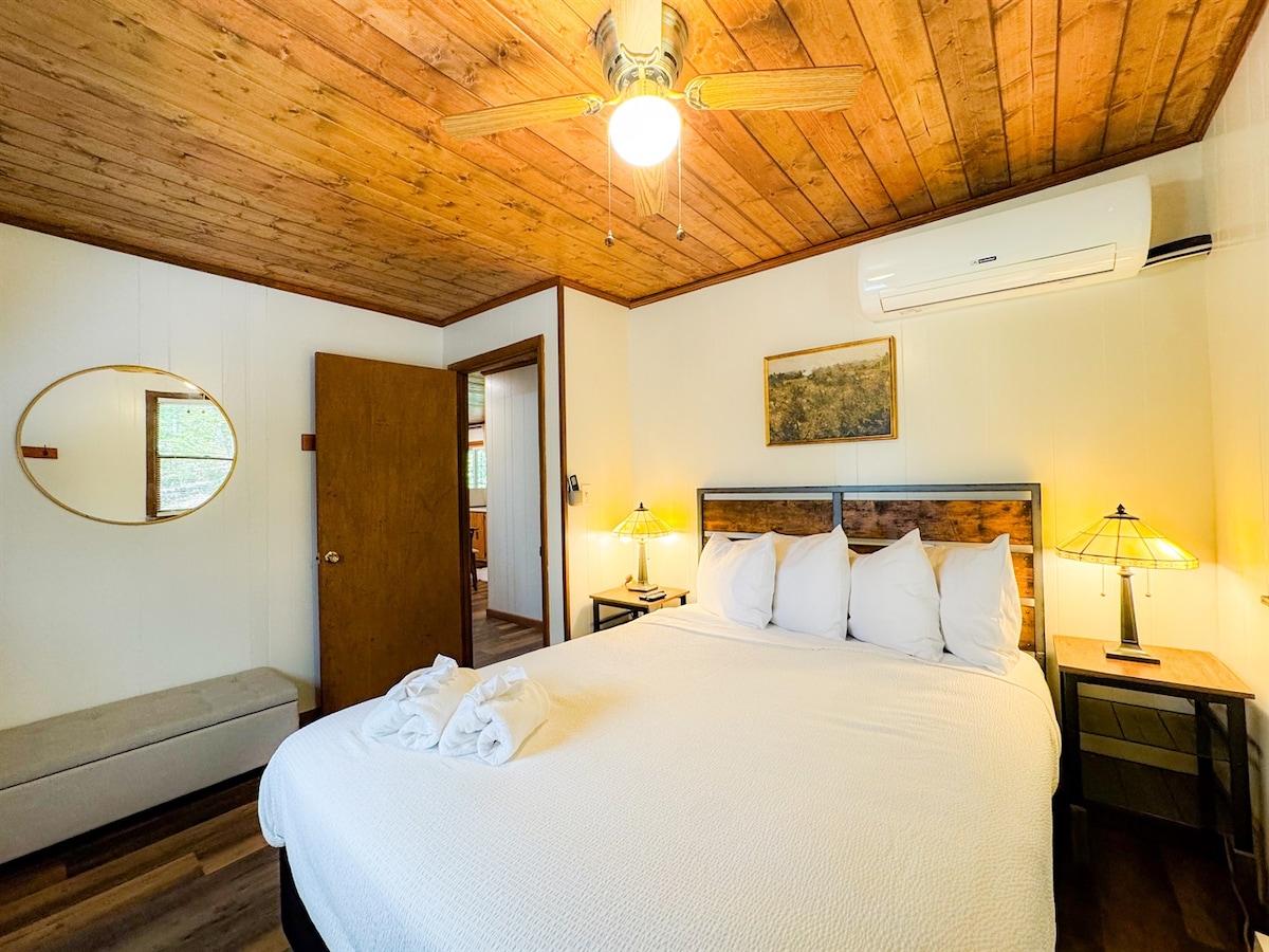 Spálňa na hlavnom poschodí má manželskú posteľ s pohodlnou posteľnou bielizňou a prikrývkami.