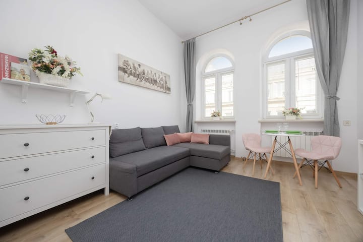 Bright interiors filled with natural light from large windows offer a cozy corner sofa and table, perfect for relaxation.