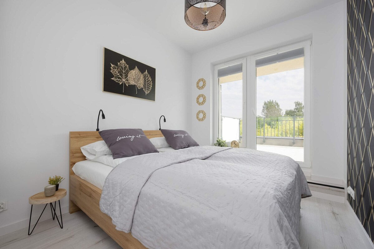 明亮的卧室配有柔软的床上用品和精致的细节，为您打造完美的休息空间，窗外绿色景观让您享受宁静的早晨。