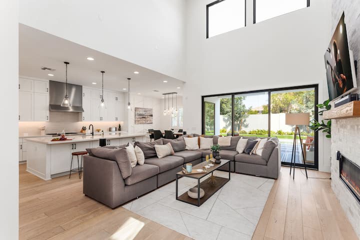 منطقة المعيشة الرئيسية تتميز بأثاث مصمم وتلفزيون ذكي ومدفأة وإمكانية الوصول إلى الفناء الخلفي.