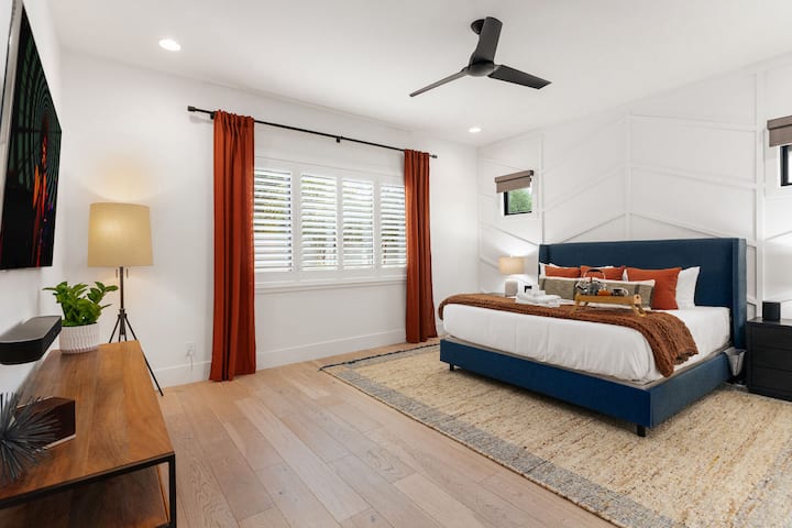 Primary Bedroom featuring a King bed, smart TV, and an en-suite bathroom with a large walk-in closet.