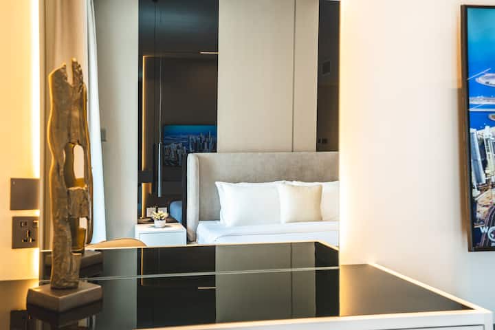 Sofisticado dormitorio principal con una lujosa cama tamaño king, armario empotrado y una elegante decoración, con baño adjunto y acceso directo al balcón para un refugio sereno.