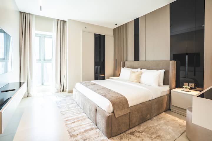 Elegante dormitorio con una lujosa cama tamaño king, un sofisticado tocador y un amplio espacio de almacenamiento, diseñado para ofrecer la máxima comodidad y estilo.