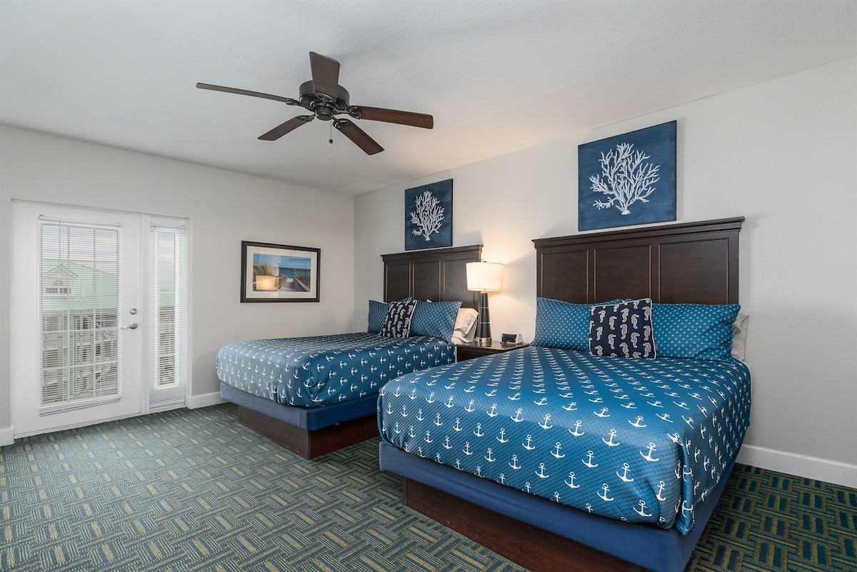 Slaapkamer (2 queensize bedden) met balkon met uitzicht op het waterpark