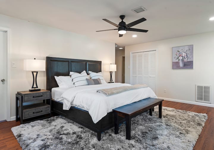 The upper-level primary bedroom features a king bed, TV and an ensuite bathroom.