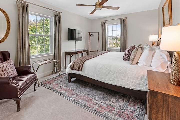 Krevat me shkumë memorieje "king" me shtroja hoteli, raft valixhesh, televizor inteligjent, tavolinë pune dhe karrige, perde të errëta dhe karrige