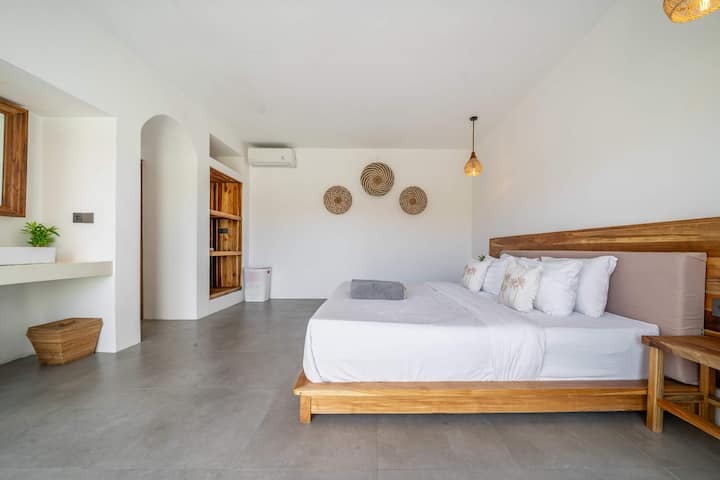 Spálňa s prirodzeným svetlom – manželská posteľ, klimatizácia a upokojujúca výzdoba.