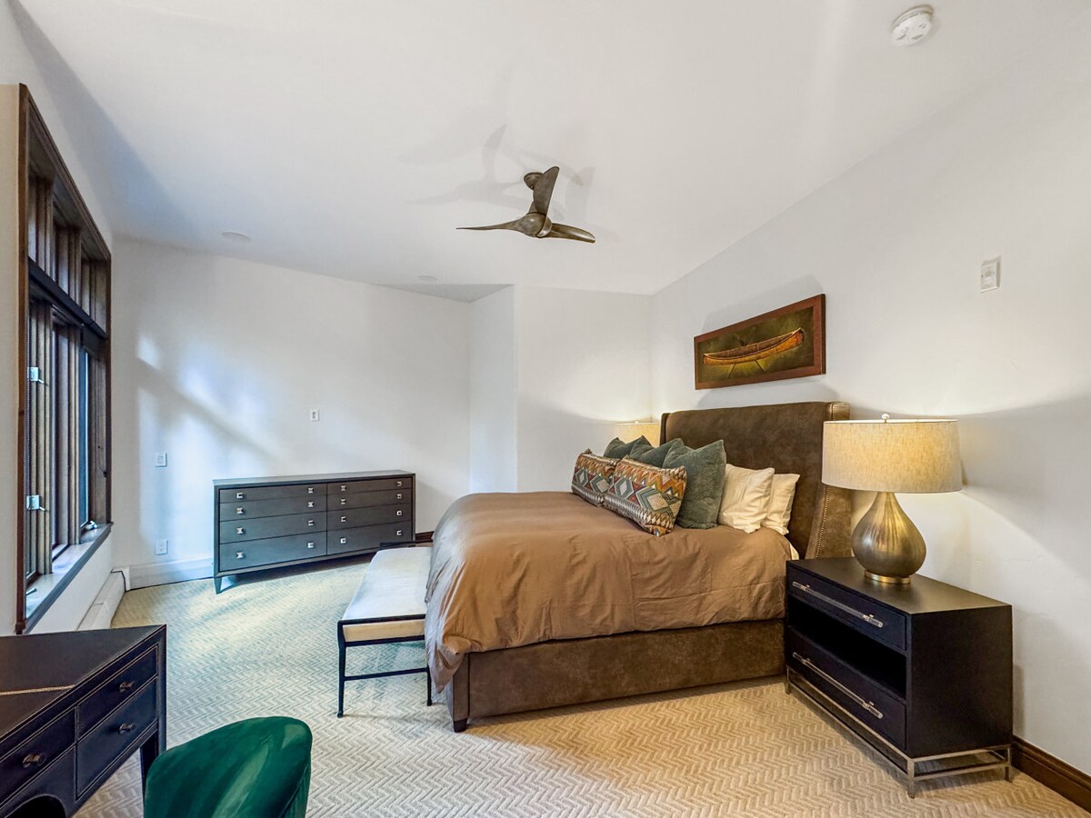 S vrata kupaonice u spavaćoj sobi možete vidjeti elegantan dizajn glavne spavaće sobe – raskošan bračni krevet postavljen tako da može iskoristiti prirodno svjetlo koje ulazi kroz velike prozore. Svako jutro uživajte u pogledu na selo