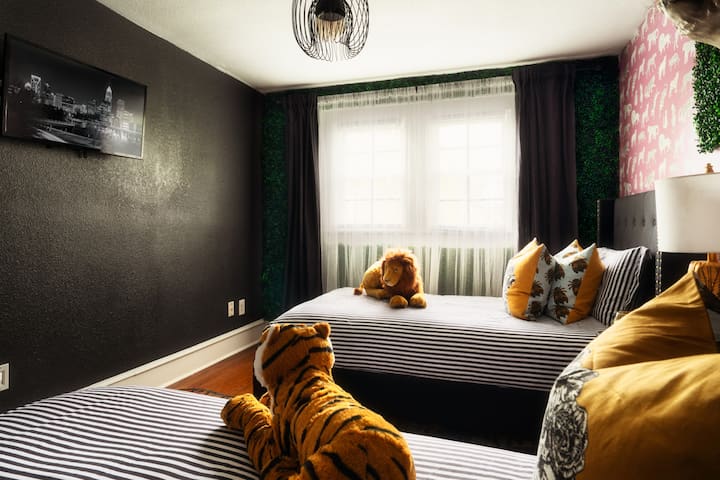 [Bedroom 3- Jungle Room] Upstairs, the Jungle Room offers two twin beds for a playful slumber party or a cozy night's sleep after exploring Discovery Place! Enjoy the added convenience of a Roku-enabled Smart TV in this room.