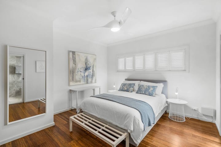 Relax in the second bedroom, styled with a queen bed, ceiling fan and quick access to the main bathroom, making it a peaceful and convenient choice for couples or solo travellers.