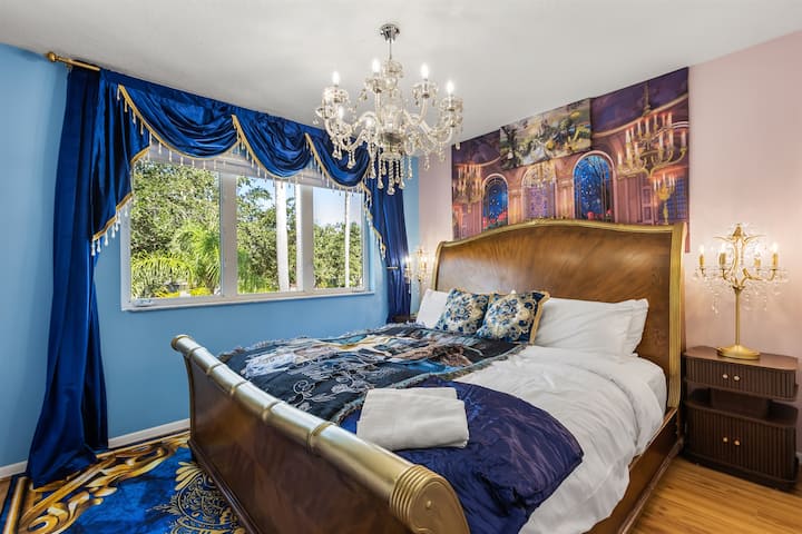 Suite La Bella y la Bestia: detalles dorados, candelabros y cortinas de color azul real capturan la magia del salón de baile de La Bella y la Bestia.