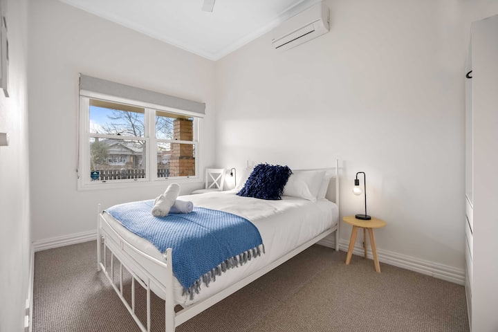 Dormitorio principal con cama tamaño queen, sistema dividido y almacenamiento.  