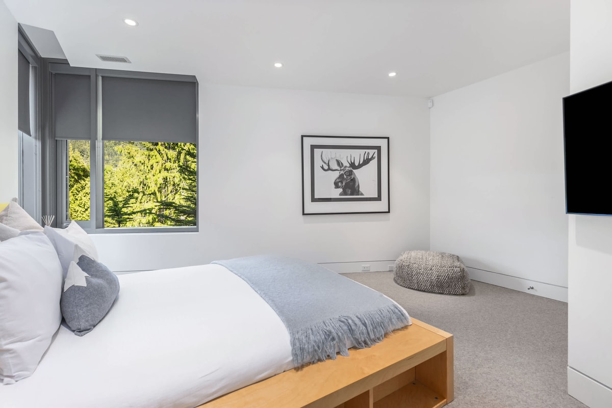 - Chambre moderne au décor minimaliste et à l'éclairage chaleureux  
- De grandes fenêtres encadrent des vues sur la forêt verdoyante à l'extérieur  
- Un havre de paix alliant confort et beauté naturelle  
