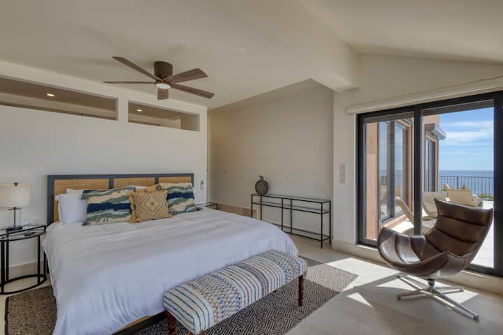 Amplio dormitorio con cama tamaño king, acceso al balcón y vistas al mar.