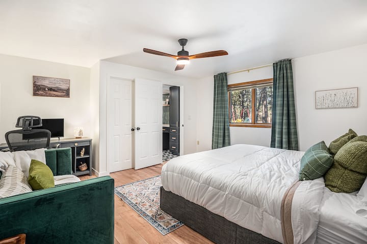 Спокойна основна спалня с двойно легло, меко осветление и спокойна гледка към гората за спокоен сън.