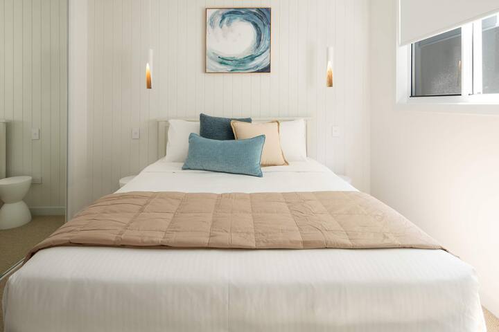 Chambre confortable avec un grand lit, des tons doux et une décoration moderne.