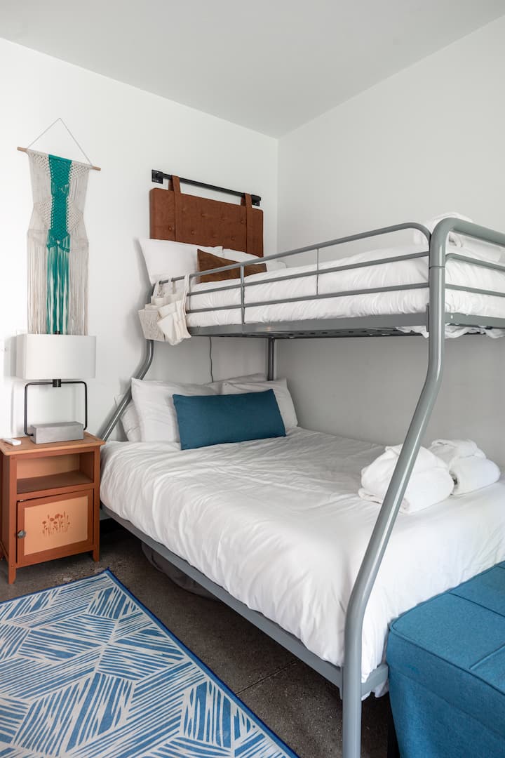 Удобен кревет на спрат со мека постелнина и прозорец кој внесува природна светлина.