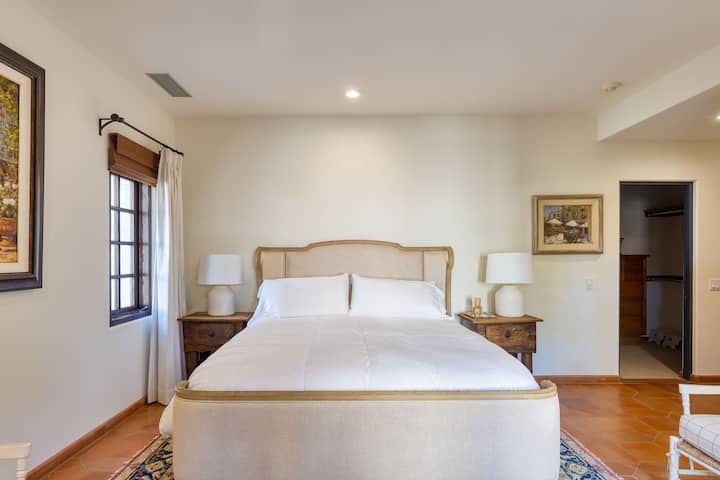 Slaapkamer 2 heeft een kingsize bed, een open haard en toegang tot de patio.