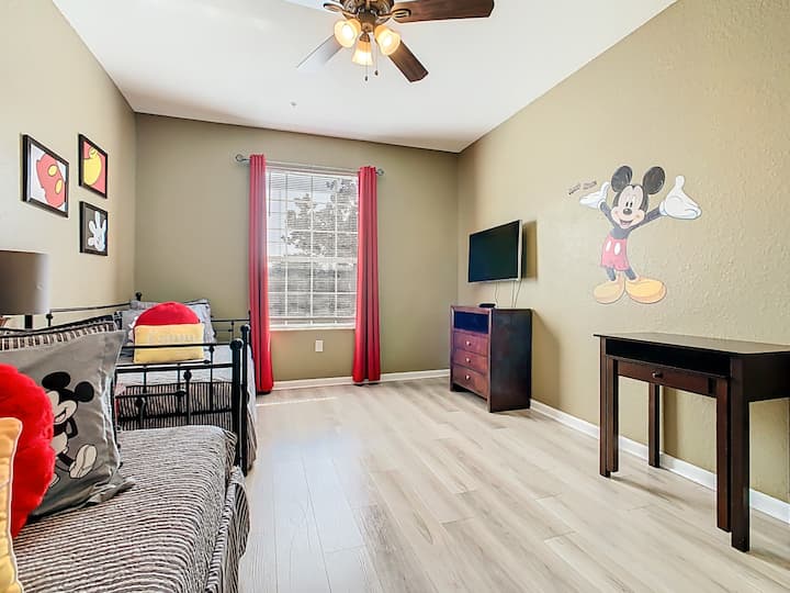Dječja spavaća soba s Disneyjevim motivima, šarenim ukrasima i televizorom – savršena za obiteljsku zabavu.