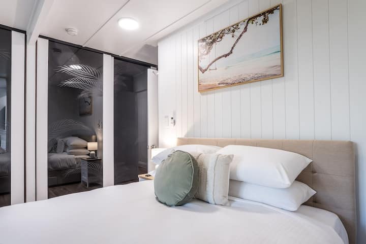 Acogedor dormitorio con elegante cabecero y arte decorativo en la pared